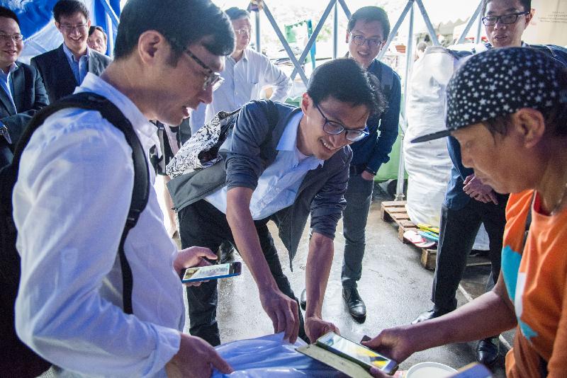 立法會議員朱凱廸（中）和何啟明（後排右二）今日（五月十五日）在香港中文大學觀看如何透過無線射頻識別電子標籤追蹤回收情況和記錄廢物量的示範。