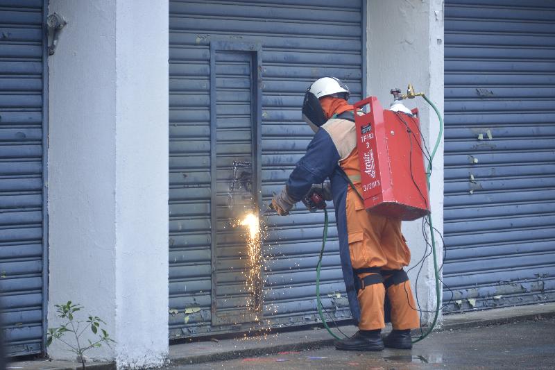 The two-day, large scale exercise codenamed "Exercise Bauhinia", biennially held by Civil Aid Service (CAS), concluded successfully today (May 21). Photo shows a rescuer breaking down the door with the arc air cutting equipment and conducting search and rescue in the building.