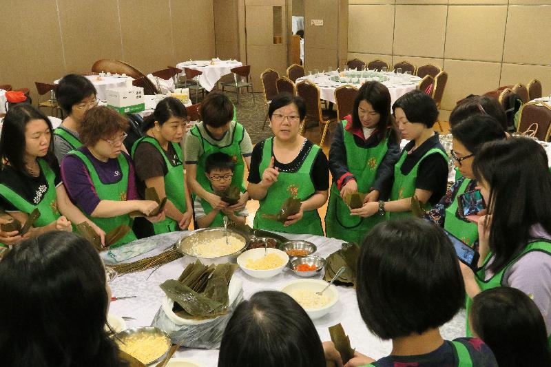 Members of the Housing Department Volunteers Corps held an afternoon gathering for elderly tenants on May 27. Photo shows members of the Volunteers Corps making rice dumplings under the guidance of a tutor.