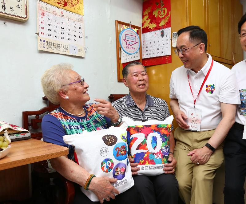 The Secretary for Innovation and Technology, Mr Nicholas W Yang (first right), visits an elderly couple in Ap Lei Chau Estate this afternoon (June 10) and gives out gift packs to share the joy of the 20th anniversary of the establishment of the Hong Kong Special Administrative Region.