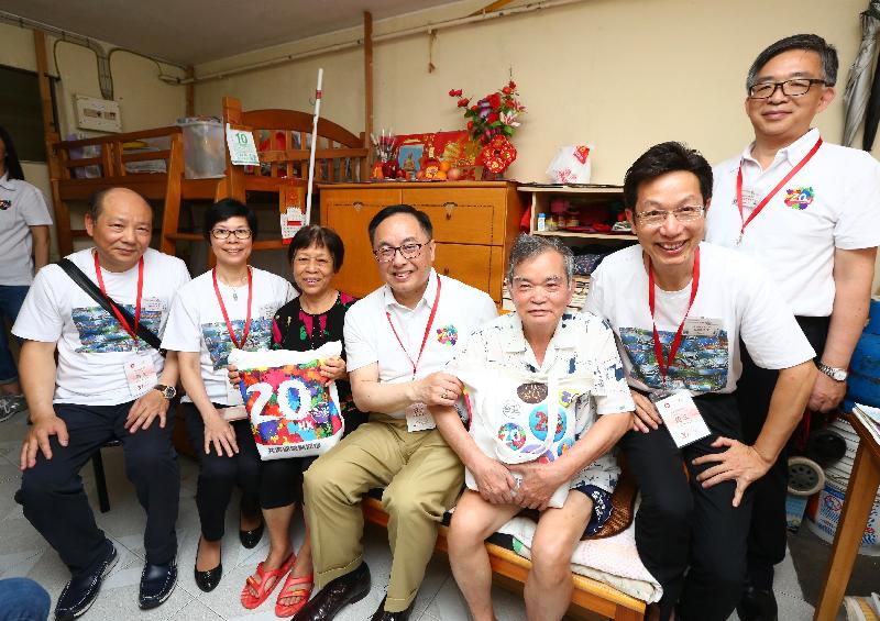 The Secretary for Innovation and Technology, Mr Nicholas W Yang (centre); the District Officer (Southern), Mr Chow Chor-tim (fist right); and the Chairman of the Southern District Council, Mr Chu Ching-hong (second right) join a group photo with an elderly couple during home visits in Ap Lei Chau Estate under the "Celebrations for All" project this afternoon (June 10).