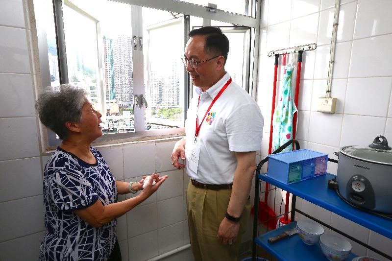 The Secretary for Innovation and Technology, Mr Nicholas W Yang (right), better understands the daily life of an elderly woman during home visits to Ap Lei Chau Estate this afternoon (June 10).