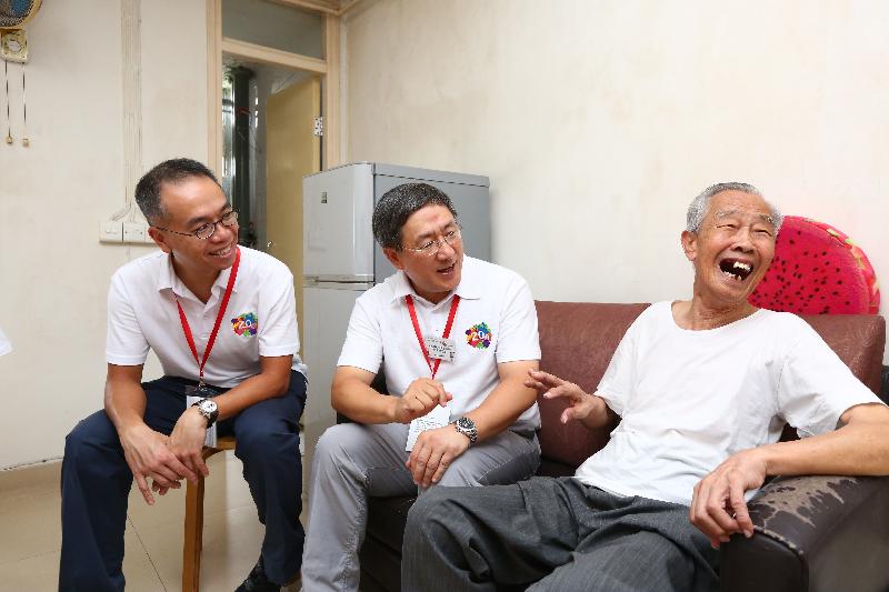 The Permanent Secretary for Innovation and Technology, Mr Cheuk Wing-hing (centre), and the Deputy Commissioner for Innovation and Technology, Mr Johann Wong (left), chat heartily today (June 10) with an elderly man living on his own.