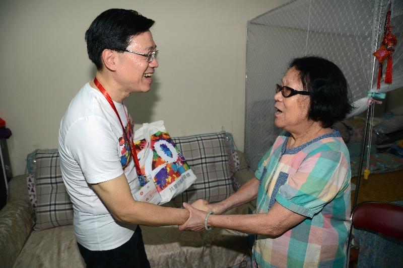 保安局副局長李家超（左）今日（六月十二日）到訪蝴蝶邨，向一個長者家庭派發禮物包。