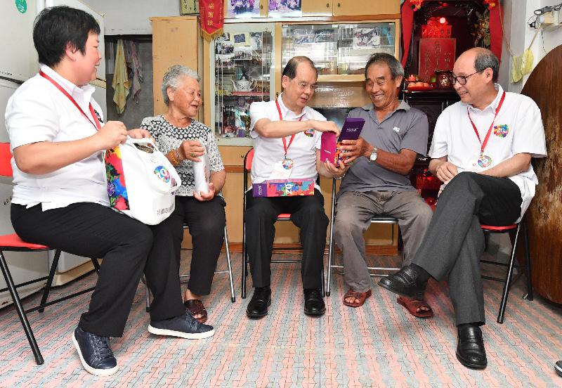 The Chief Secretary for Administration, Mr Matthew Cheung Kin-chung, conducted home visits in Tai Po District under the "Celebrations for All" project today (June 16). Photo shows Mr Cheung (centre) presenting a gift pack to a family to share the joy of the 20th anniversary of the establishment of the Hong Kong Special Administrative Region.