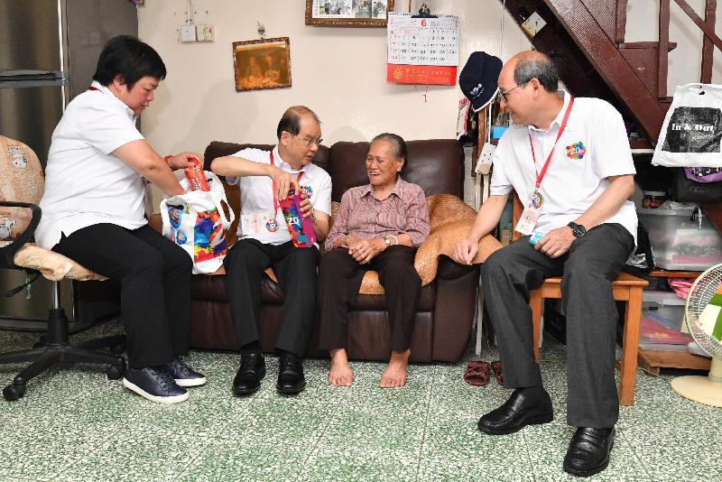 The Chief Secretary for Administration, Mr Matthew Cheung Kin-chung, conducted home visits in Tai Po District under the "Celebrations for All" project today (June 16). Photo shows Mr Cheung (second left) presenting a gift pack to an elderly lady to share the joy of the 20th anniversary of the establishment of the Hong Kong Special Administrative Region.