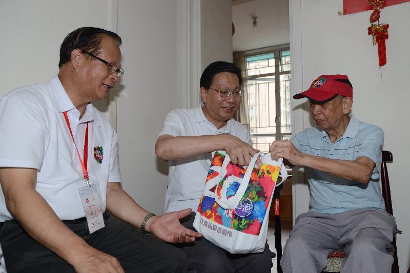 The Secretary for Transport and Housing, Professor Anthony Cheung Bing-leung (centre), visits the elderly at Oi Tung Estate in Shau Kei Wan under the "Celebrations for All" project today (June 17). Picture shows Professor Cheung giving a gift pack to the elderly to share the joy of the 20th anniversary of the establishment of the Hong Kong Special Administrative Region.