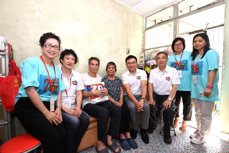 The Secretary for Financial Services and the Treasury, Professor K C Chan (fourth right); the Under Secretary for Financial Services and the Treasury, Mr James Lau (third right); and the District Officer (Tsuen Wan), Miss Jenny Yip (second left), join a group photo with an elderly couple during home visits at Shek Wai Kok Estate in Tsuen Wan under the "Celebrations for All" project this afternoon (June 23).