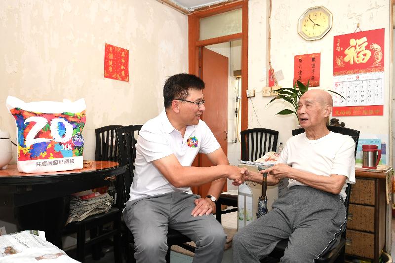 The Secretary for Financial Services and the Treasury, Professor K C Chan (left), visits an elderly singleton at Shek Wai Kok Estate this afternoon (June 23).