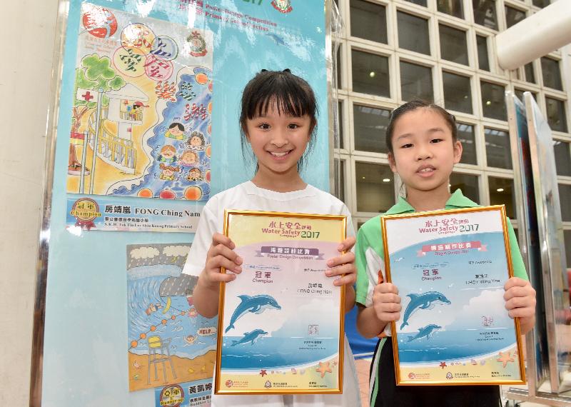 Awards for the water safety slogan and poster design competitions organised by the Leisure and Cultural Services Department and the Hong Kong Life Saving Society were presented today (June 24). Pictured with her winning entry is Fong Ching-nam (left), the champion of the primary school section in the Water Safety Poster Design Competition. Choy Wing-yee (right) is the champion of the primary school section in the Water Safety Slogan Competition.
