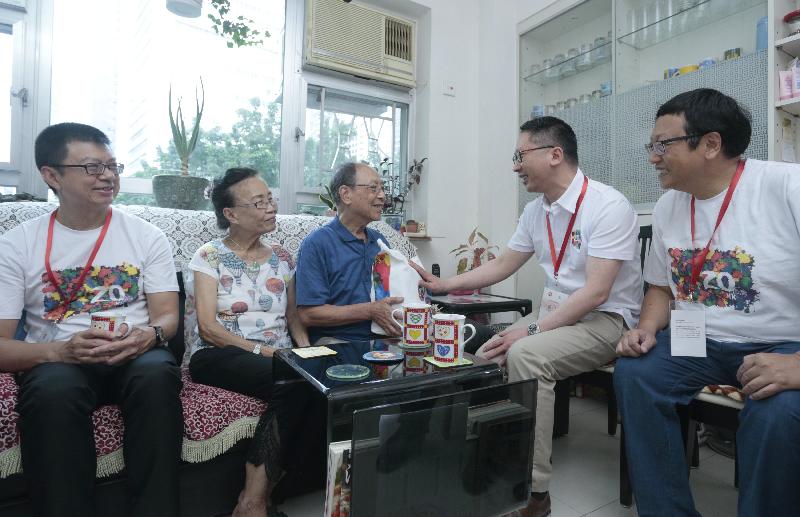 The Secretary for Justice, Mr Rimsky Yuen, SC, today (June 27) visited families in Wan Chai District to learn more about their living conditions and needs, as well as present gift packs to them. Photo shows Mr Yuen (second right) presenting a gift pack to an elderly couple. Joining the visit are the District Officer (Wan Chai), Mr Rick Chan (first left), and the Chairman of the Wan Chai District Council, Mr Stephen Ng (first right).
