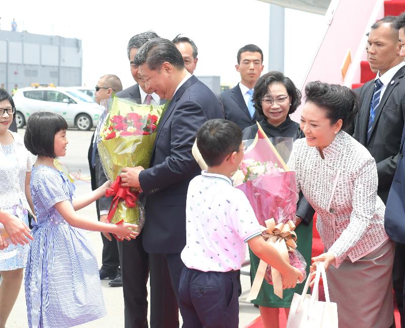 President Xi Jinping (second left) and his wife Peng Liyuan (first right) receive welcome bouquets of flowers from two children after arriving in Hong Kong today (June 29).