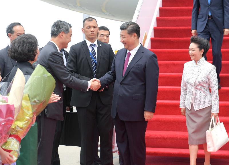 President Xi Jinping (second right) and his wife Peng Liyuan (first right) are greeted by the Chief Executive, Mr C Y Leung (second left), and his wife Mrs Regina Leung (first left) at the airport apron today (June 29).
