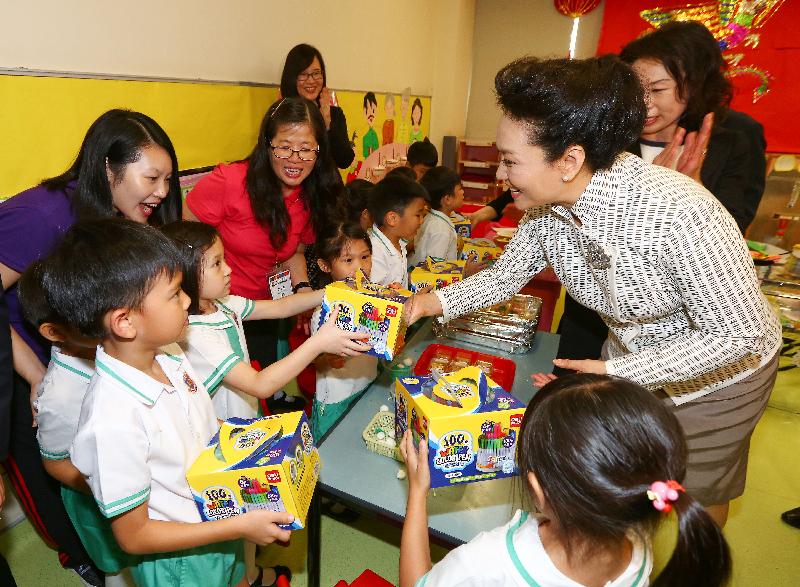 The wife of President Xi Jinping, Peng Liyuan (right), visits Yau Yat Chuen School today (June 29) and presents drawing pens to the students, as well as multimedia teaching aids to the kindergarten.