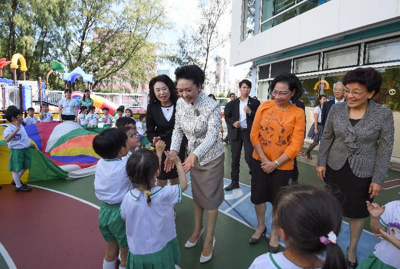 The wife of President Xi Jinping, Peng Liyuan (second left), accompanied by the wife of the Chief Executive, Mrs Regina Leung (second right), observes outdoor activities of kids at Yau Yat Chuen School today (June 29). Looking on are the Deputy Director of the Liaison Office of the Central People's Government in the Hong Kong Special Administrative Region Ms Yin Xiaojing (first right) and the kindergarten's principal, Ms Lee Ming-chu (first left).