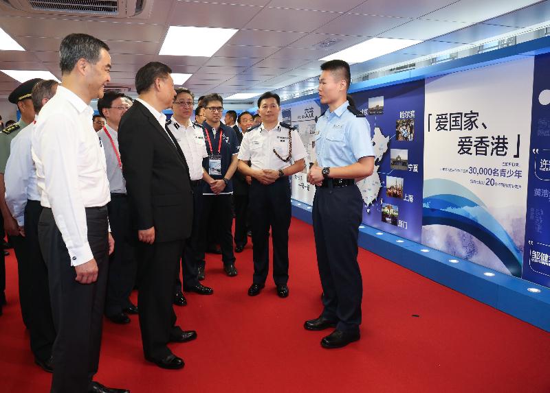 President Xi Jinping (third left) views exhibition panels and is briefed about the Junior Police Call (JPC) Scheme during his visit to the JPC Permanent Activity Centre and Integrated Youth Training Camp today (June 30). Looking on are the Chief Executive, Mr C Y Leung (first left); the Commissioner of Police, Mr Lo Wai-chung (fourth left); and the Under Secretary for Security, Mr John Lee (second left).