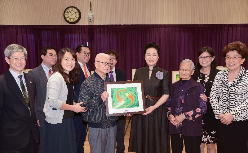 The wife of President Xi Jinping, Peng Liyuan (fourth right), visits senior citizens at TWGHs Jockey Club Sunshine Complex for the Elderly in Wong Chuk Hang this morning (June 30), and receives from two elderly representatives their water colour painting as a token of thanks for her visit. Looking on are Deputy Director of the Liaison Office of the Central People's Government in the Hong Kong Special Administrative Region, Ms Yin Xiaojing (first right); the Secretary for Labour and Welfare, Mr Stephen Sui (fifth right); and the Chairman of the Tung Wah Group of Hospitals, Dr Lee Yuk-lun (fourth left).