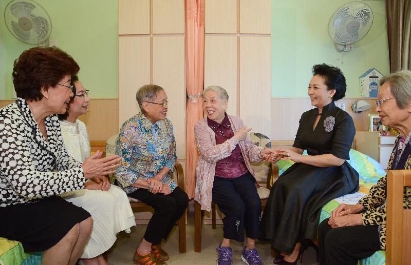 The wife of President Xi Jinping, Peng Liyuan (second right), this morning (June 30) chats with residents of Jockey Club Harmony Villa, the residential block of TWGHs Jockey Club Sunshine Complex for the Elderly in Wong Chuk Hang, to learn about their daily lives. Those joining her in the visit include the wife of the Chief Executive, Mrs Regina Leung (second left), and Deputy Director of the Liaison Office of the Central People's Government in the Hong Kong Special Administrative Region, Ms Yin Xiaojing (first left).