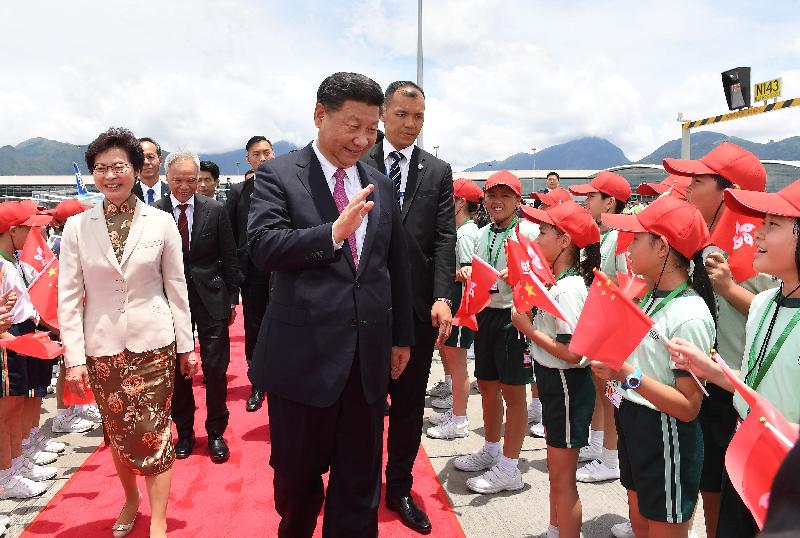 國家主席習近平（中）今日（七月一日）離港前在機場向送行的小童揮手道別。行政長官林鄭月娥（左一）及丈夫林兆波（左二）亦有送行。