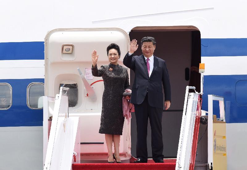 President Xi Jinping (right) and his wife Peng Liyuan (left) wave to people seeing them off at the airport before their departure today (July 1).