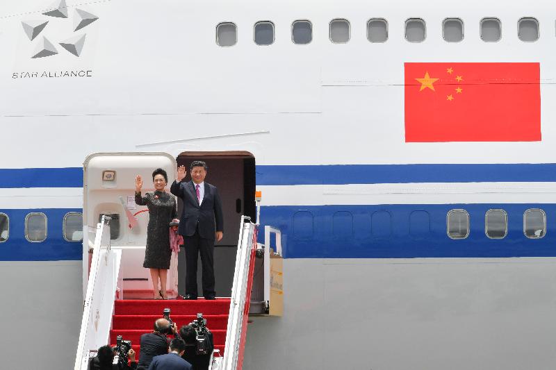 President Xi Jinping (right) and his wife Peng Liyuan (left) wave to people seeing them off at the airport before their departure today (July 1).
