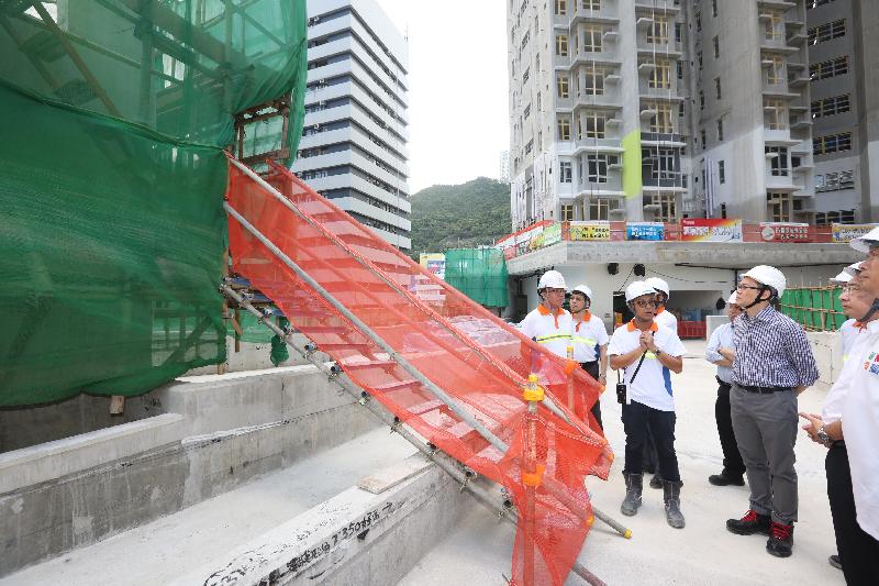 The Commissioner for Labour, Mr Carlson Chan, today (July 11) visited a public housing construction site in Kwai Chung and attended a safety talk which was aimed at strengthening workers' awareness on occupational safety and health. Photo shows Mr Chan observing that closely boarded bamboo scaffolding was adopted at every lift of the external wall scaffolding. This scaffolding design is considered effective in preventing workers from falling when working on scaffolds.