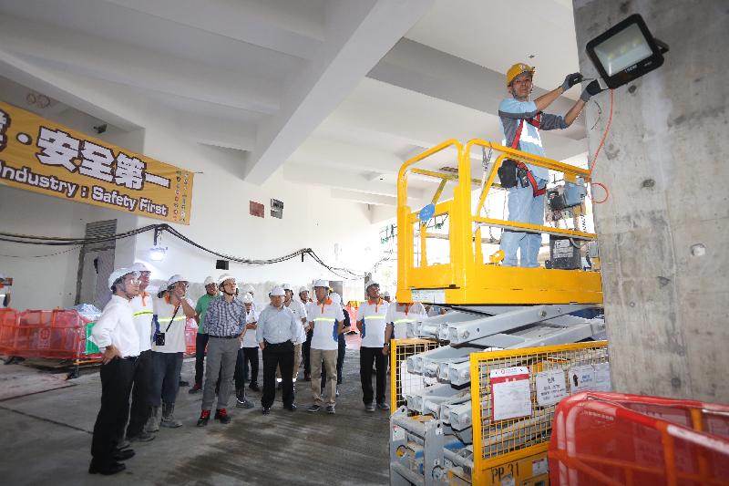 The Commissioner for Labour, Mr Carlson Chan, today (July 11) visited a public housing construction site in Kwai Chung and attended a safety talk which was aimed at strengthening workers' awareness on occupational safety and health. Photo shows Mr Chan looking on as a worker uses a safety platform when working at height.