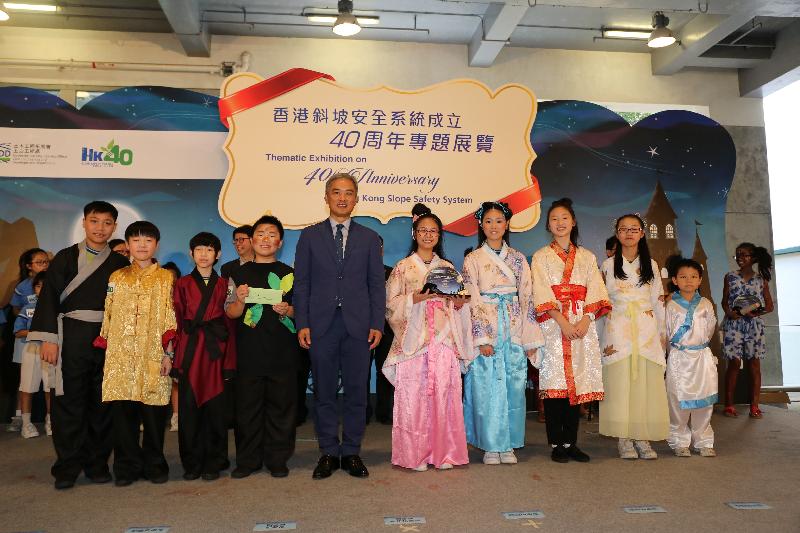 The Director of Fire Services, Mr Daryl Li (fifth left), presents a prize to the representative of Pak Tin Catholic Primary School, the champion of the Inter-Primary School Slope Safety Drama Competition organised by the Geotechnical Engineering Office, at the opening ceremony of the "Thematic Exhibition on 40th Anniversary of Hong Kong Slope Safety System" at PMQ, Central, today (July 14).