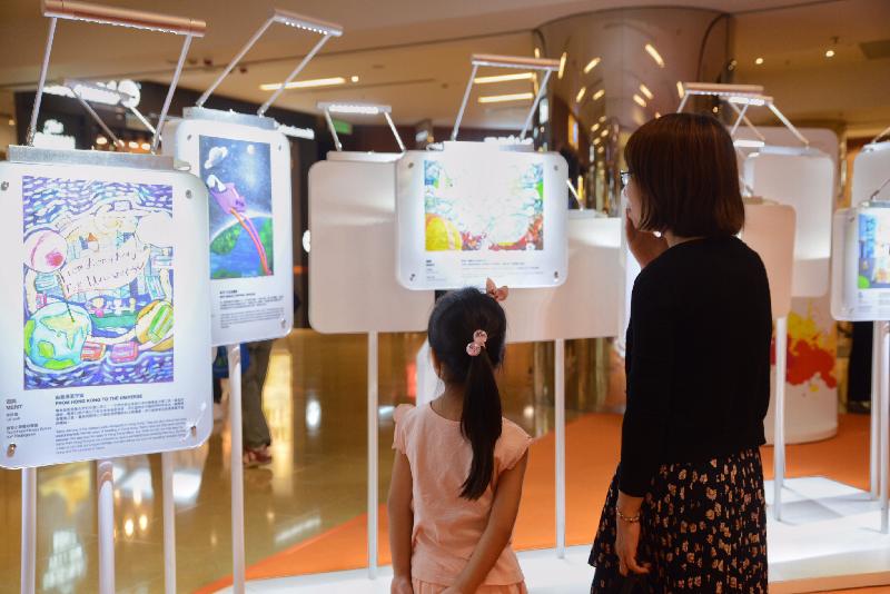 「香港特別行政區成立二十周年巡迴展覽」今日（七月十五日）起在太古城中心舉行。圖示參觀展覽的市民欣賞特區成立二十周年海報設計比賽的得奬作品。