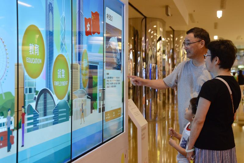 「香港特別行政區成立二十周年巡迴展覽」今日（七月十五日）起在太古城中心舉行。圖示參觀展覽的市民通過電子觸控式屏幕，回顧香港過去二十年的發展和成就。 