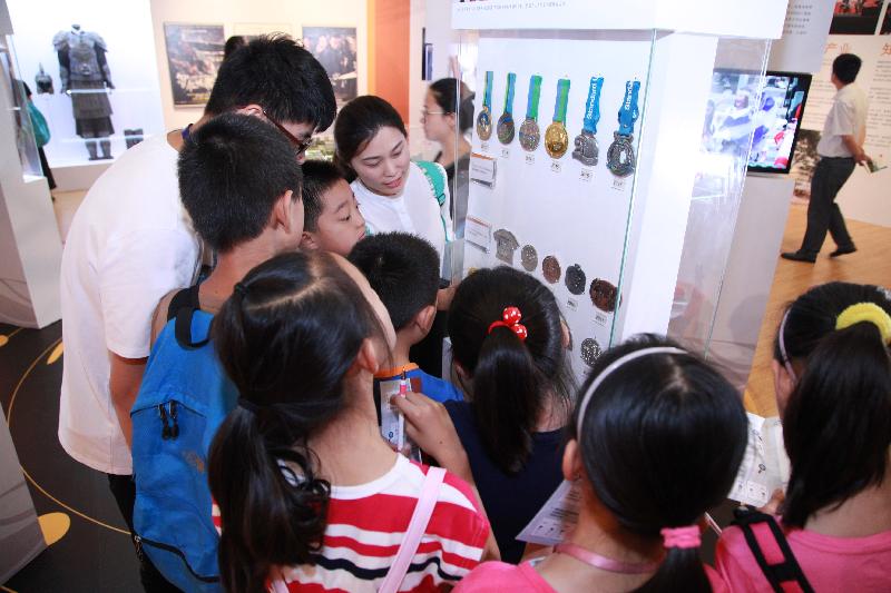 The "Together · Progress · Opportunity - Exhibition in Celebration of the 20th Anniversary of the Return of Hong Kong to the Motherland" organised by the Hong Kong Special Administration Region Government at the National Museum of China in Beijing was successfully concluded today (July 16). Children showing special interest in the sports medal exhibits.