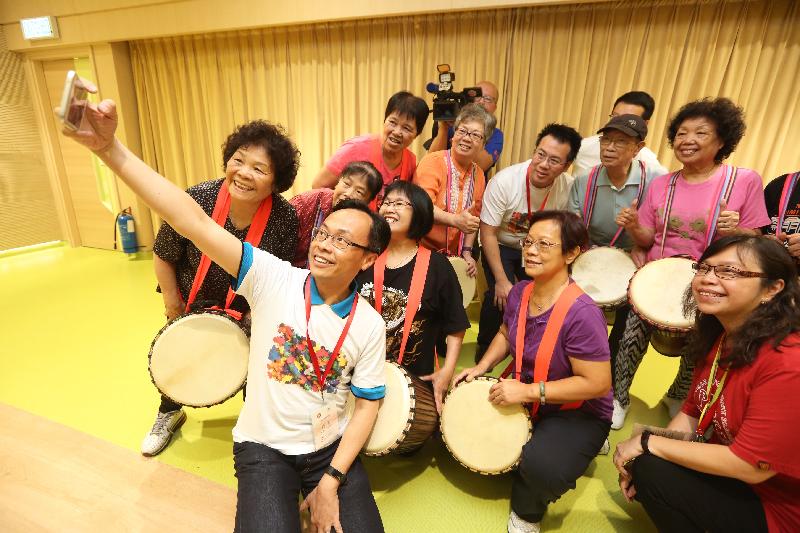 The Secretary for Constitutional and Mainland Affairs, Mr Patrick Nip (front), takes a selfie with a group of elderly people attending a music class at the Po Leung Kuk Lau Chan Siu Po District Elderly Community Centre in Kwun Tong today (July 18).