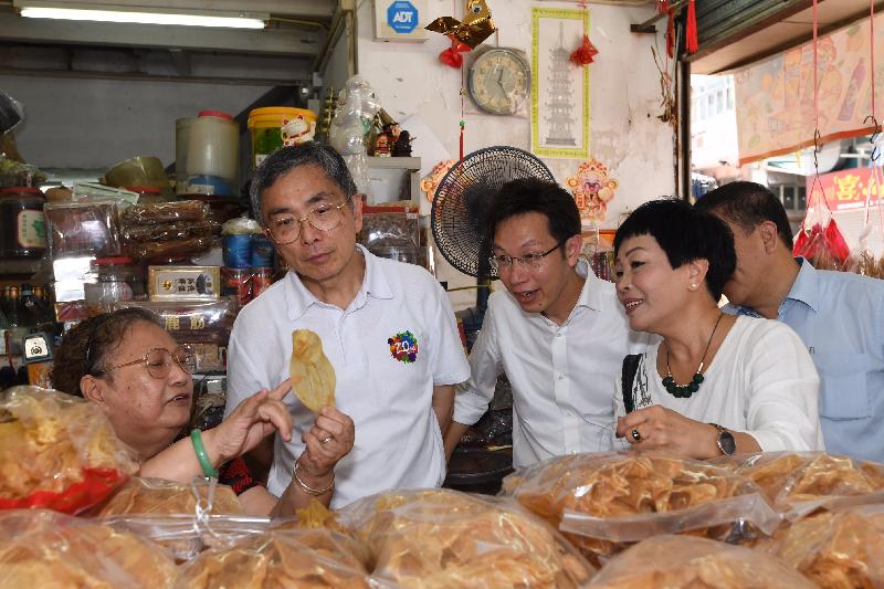 The Secretary for Financial Services and the Treasury, Mr James Lau (second left), visits a local dried seafood store in Southern District and chats with the shop owner this morning (July 19).