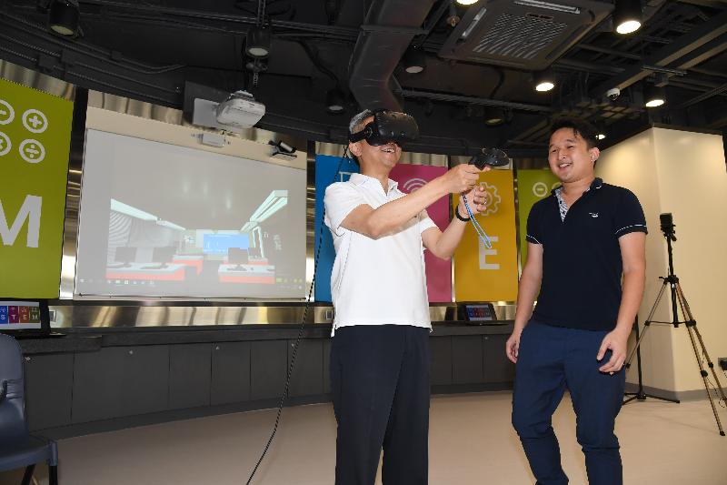 公務員事務局局長羅智光（左）今日（七月二十四日）到訪東區時參觀了香港專業教育學院（柴灣）。圖示羅智光試用學生研發的虛擬實境技術系統。