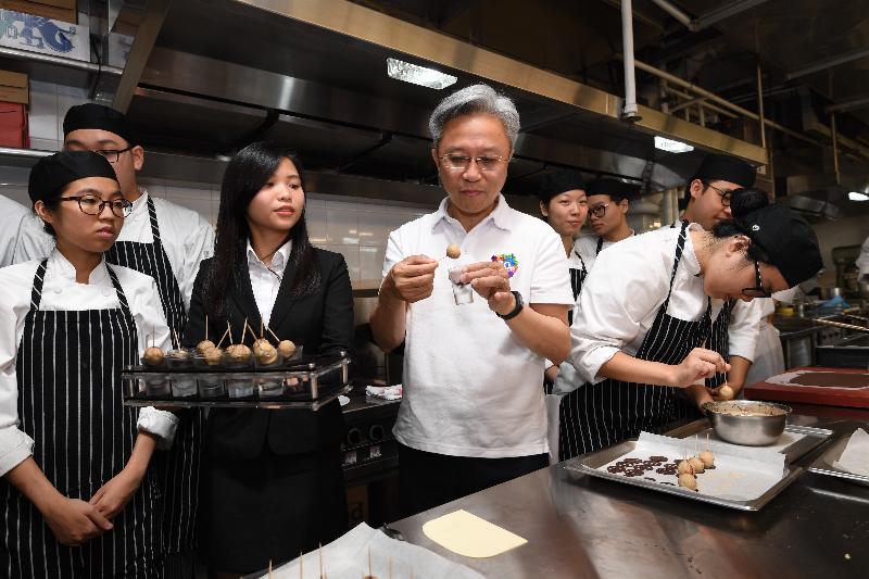 At the Hong Kong Institute of Vocational Education (Chai Wan) today (July 24), the Secretary for the Civil Service, Mr Joshua Law (third left), tastes a dessert made by students in the Asian Training Restaurant and Training Kitchen.
