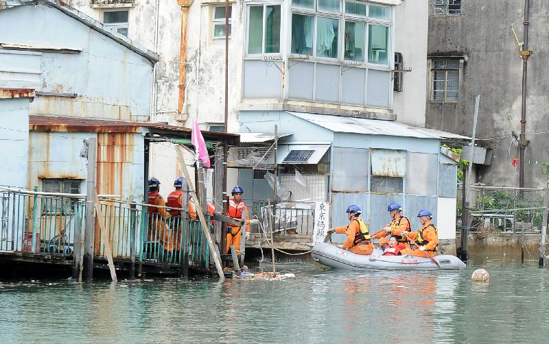 The Islands District Office conducted an inter-departmental rescue and evacuation drill in Tai O today (July 24). Photo shows Civil Aid Service members rescuing trapped residents by boat in the drill.
