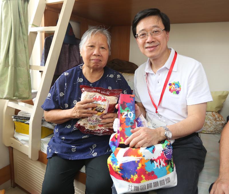 The Secretary for Security, Mr John Lee (right), today (July 26) presents a gift pack of the 20th anniversary of the establishment of the Hong Kong Special Administrative Region to an elderly resident in Yan On Estate.