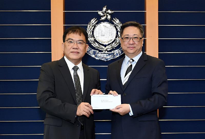 警務處處長盧偉聰（右）頒授委任狀予新任香港輔助警察隊副總監鄭文森（左）。