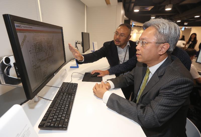 During his visit to the Buildings Department today (July 31), the Secretary for the Civil Service, Mr Joshua Law (right), tours the Building Information Centre to learn about its services to members of the public.