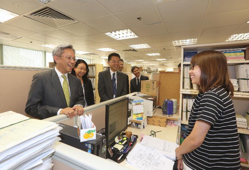In touring the Existing Buildings Division of the Buildings Department today (July 31), the Secretary for the Civil Service, Mr Joshua Law (left), chats with front-line staff to learn more about their work.