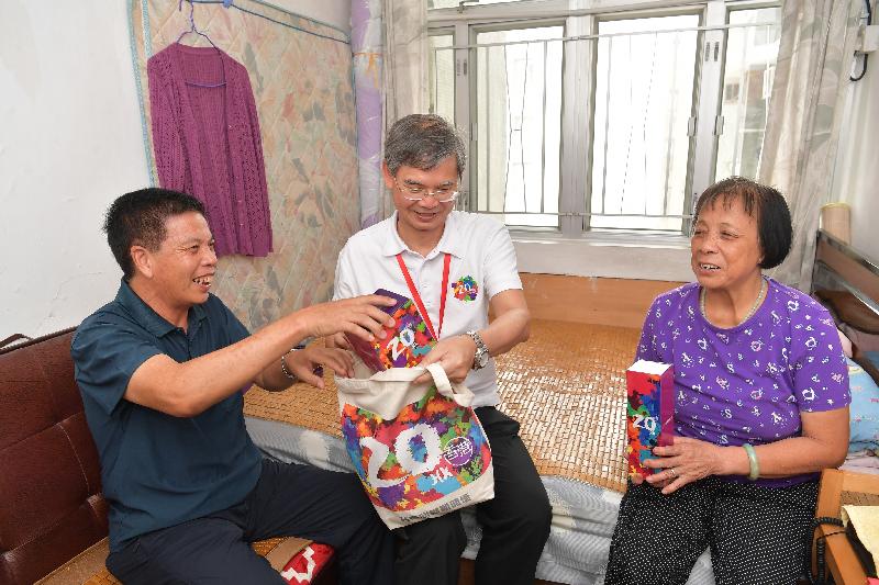 The Secretary for Labour and Welfare, Dr Law Chi-kwong (centre), visits an elderly family and presents a gift pack to them in Yuen Long District under the "Celebrations for All" project this afternoon (July 31).