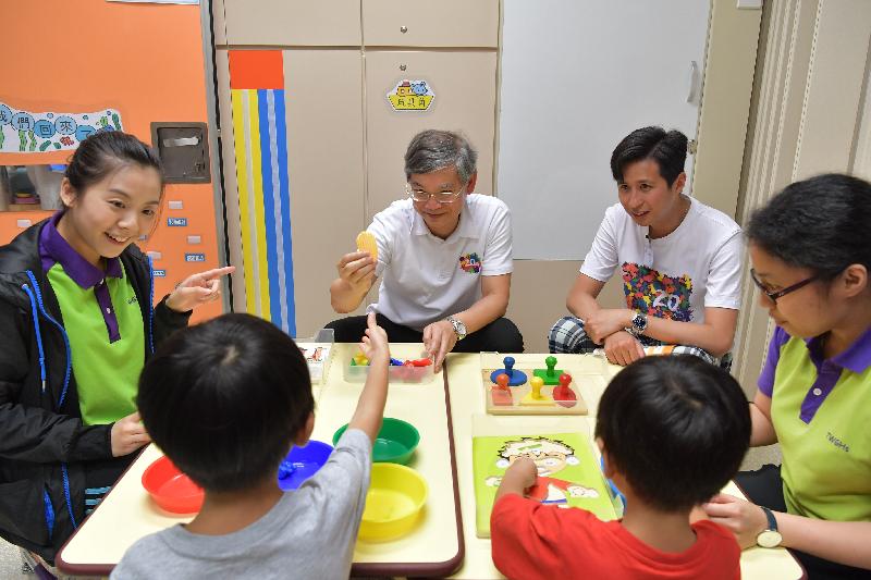 The Secretary for Labour and Welfare, Dr Law Chi-kwong, visited the Tung Wah Group of Hospitals Mr and Mrs Liu Lit Mo Child Development Centre at the Tin Ching Amenity and Community Building at Tin Ching Estate in Tin Shui Wai this afternoon (July 31). Picture shows Dr Law (second left); the Chairman of the Yuen Long District Council, Mr Shum Ho-kit (third left); and staff of the centre interacting with children with special needs.