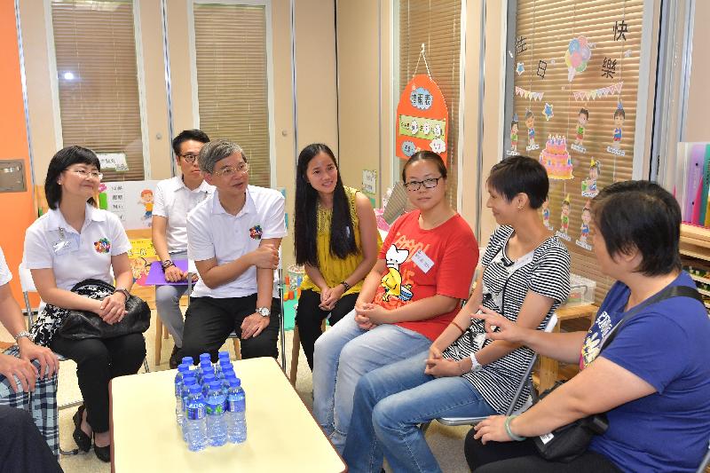 The Secretary for Labour and Welfare, Dr Law Chi-kwong, visited the Tung Wah Group of Hospitals Mr and Mrs Liu Lit Mo Child Development Centre at the Tin Ching Amenity and Community Building at Tin Ching Estate in Tin Shui Wai this afternoon (July 31). Picture shows Dr Law (second left) and the Permanent Secretary for Labour and Welfare, Ms Chang King-yiu (first left), meeting with parents of service recipients.