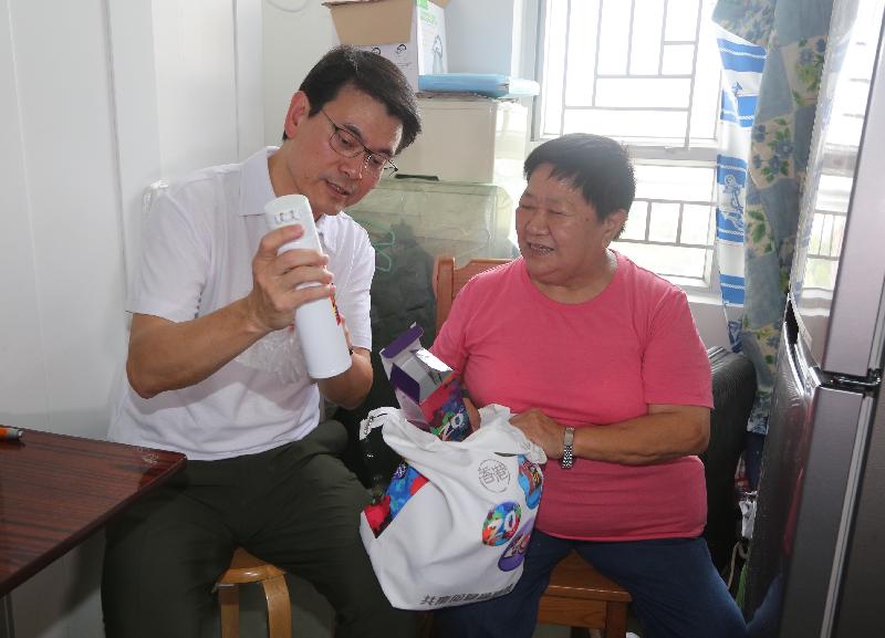 The Secretary for Commerce and Economic Development, Mr Edward Yau (left), visited an elderly woman living in Cheung Lung Wai Estate in Sheung Shui during his visit in North District today (August 1). Mr Yau learned about her needs and daily life and gave a gift pack to her.