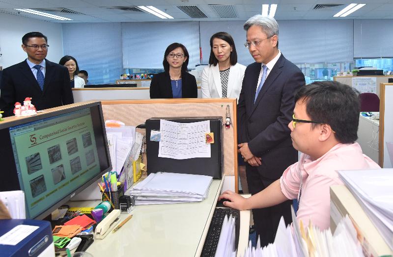 During his visit to the Social Welfare Department today (August 2), the Secretary for the Civil Service, Mr Joshua Law (second right), chats with staff of the Causeway Bay Social Security Field Unit to learn more about their work.