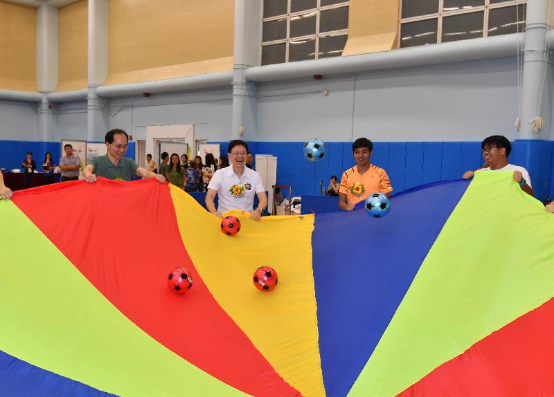 The Secretary for Security, Mr John Lee (second left), participates in rhythmic movement and rainbow parachute games to promote social integration among people with and without disabilities, at the Kowloon Park Sports Centre in Yau Tsim Mong District on the Sport For All Day 2017 today (August 6).