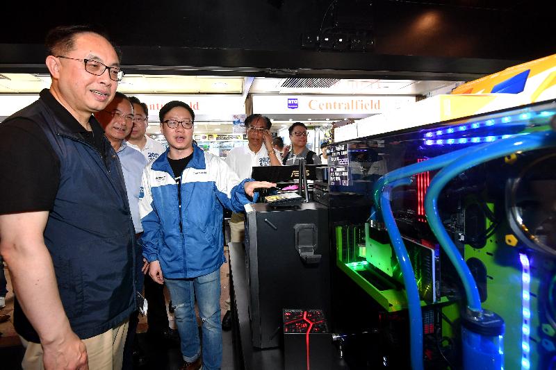 創新及科技局局長楊偉雄（左一）今日（八月六日）下午參觀深水埗區電腦主題商場，聽取店員介紹。