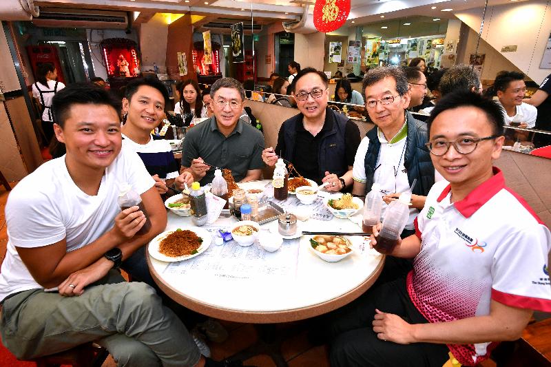 The Secretary for Innovation and Technology, Mr Nicholas W Yang (third right), enjoys local delicacies during his district visit to Sham Shui Po this afternoon (August 6).