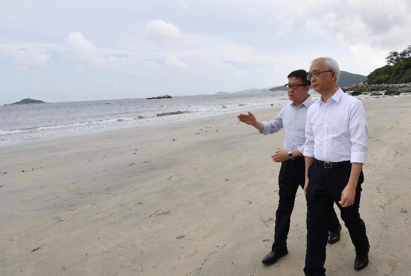Accompanied by staff from the Leisure and Cultural Services Department, the Under Secretary for the Environment, Mr Tse Chin-wan (right), visits Upper Cheung Sha Beach on Lantau Island today (August 9) to see the progress of the cleaning up of palm stearin.