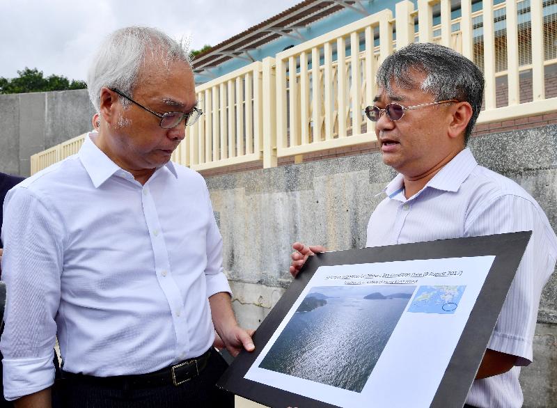 The Under Secretary for the Environment, Mr Tse Chin-wan (left), visits Upper Cheung Sha Beach on Lantau Island today (August 9) to see the progress of the cleaning up of palm stearin. He was briefed by a representative from the Environmental Protection Department on the latest situation at the southwestern waters of Hong Kong Island.